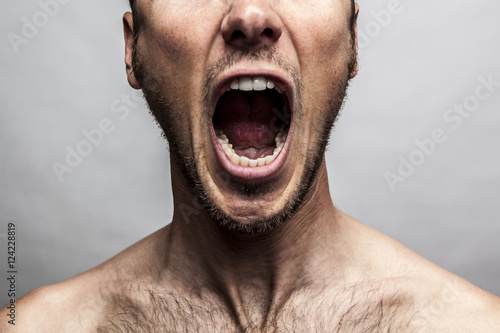 close up portrait of a man shouting, mouth wide open photo