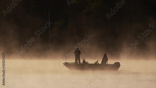Two fishermen on boat in foggy lake