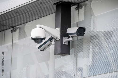 Various security cameras at office glass building exterior