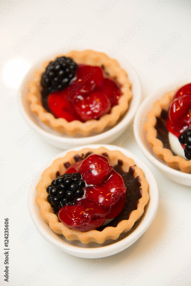 mini cherry pies/tarts on plates garnished with blackberry mini cherry pies/tarts on plates garnished with blackberry