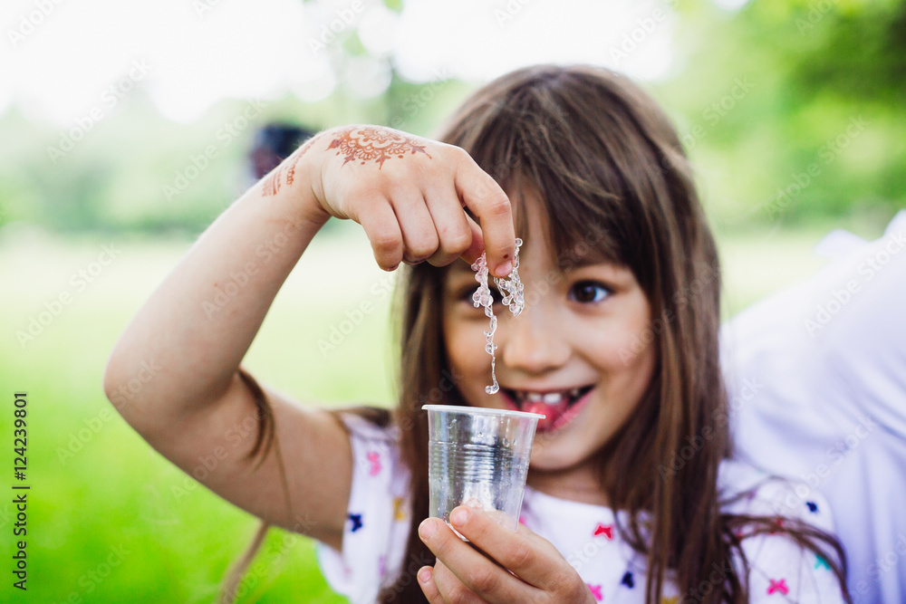 Funny little girl takes a necklace from the glass Funny little girl takes a necklace from the glass