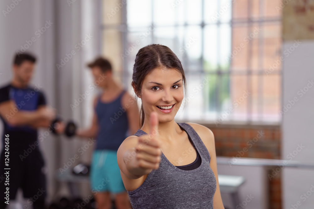 Φωτογραφία glückliche frau im fitness-studio zeigt daumen hoch