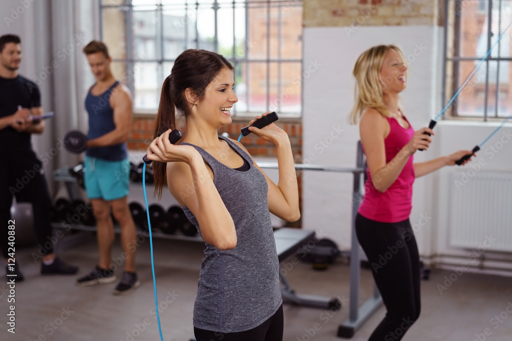 lachende frauen beim seilspringen im fitnessstudio lachende frauen beim seilspringen im fitnessstudio