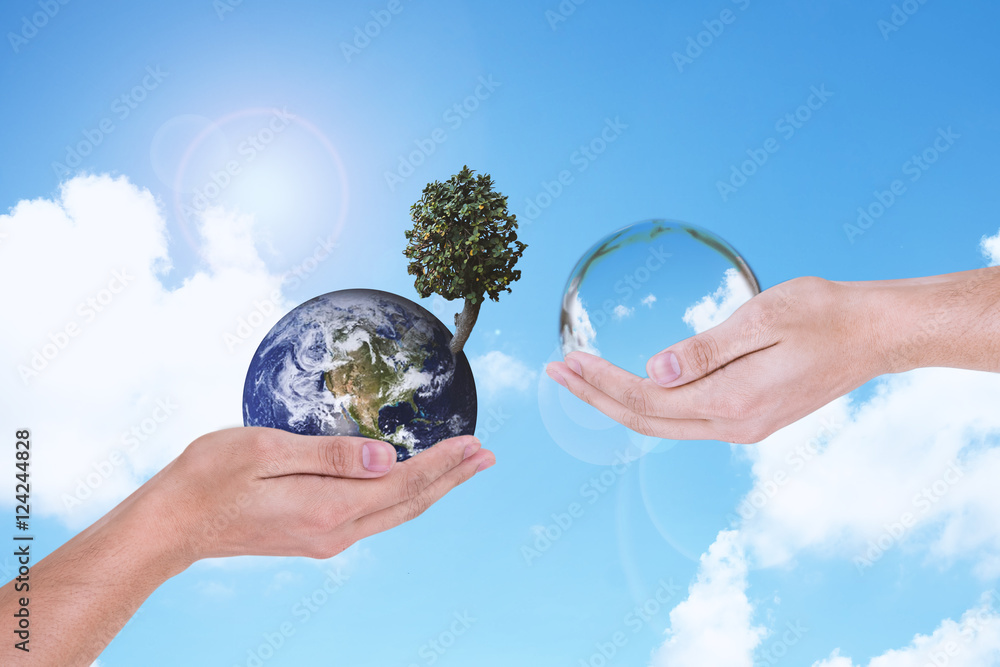 Φωτογραφία Man's hand is holding and giving water element to Man's hand is holding the earth and a tree with green natural background and light on top of left