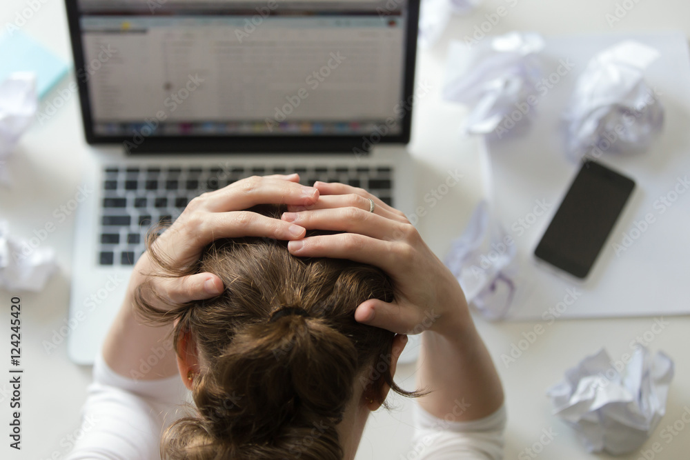Φωτογραφία Top view portrait of a woman grabbing her head in despair at the desk near the laptop