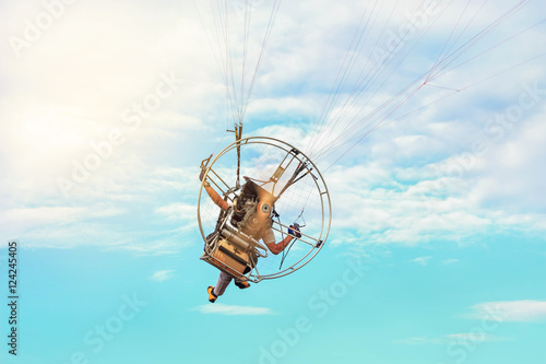 rear view paraglider fly with paramotor flying in the air on  blue  sky  background