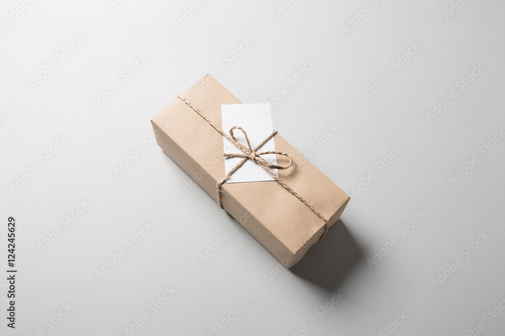 Package with rope and greeting card on gray background Package with rope and greeting card on gray background