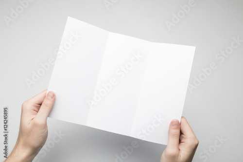 Hands are holding a Dl Tri-Fold white paper Flyer © SQS