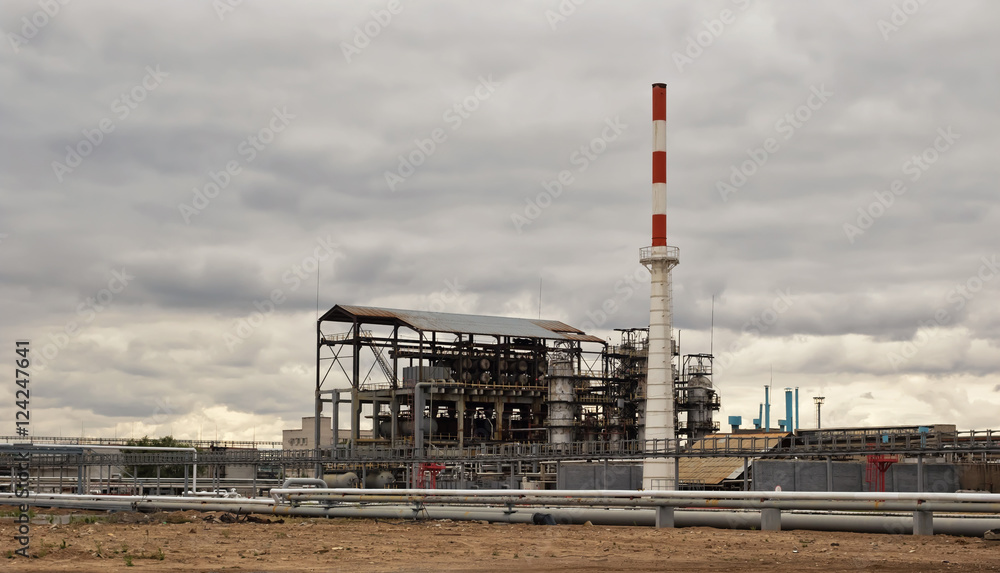 Old installation of a refinery smokestack under cloudy sky Old installation of a refinery smokestack under cloudy sky