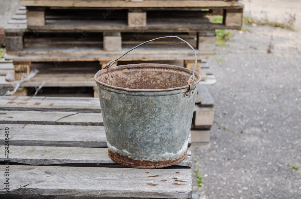 an old iron bucket in the garden at wooden pallet / an old rusty bucket / Old galvanised bucket / an old iron bucket in the garden at wooden pallet / an old rusty bucket / Old galvanised bucket /