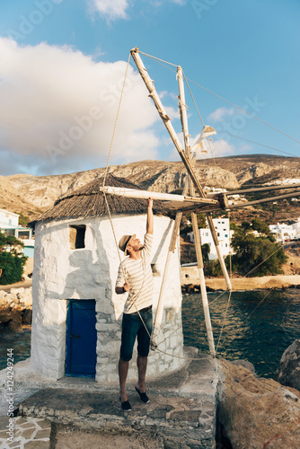 Greece, Amorgos, Aegialis, man holding the  blades of wind mill photo