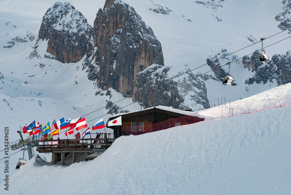 Naklejka premium Ski hut chalet mountain peak restaurant at ski slope with national flags sun terrace