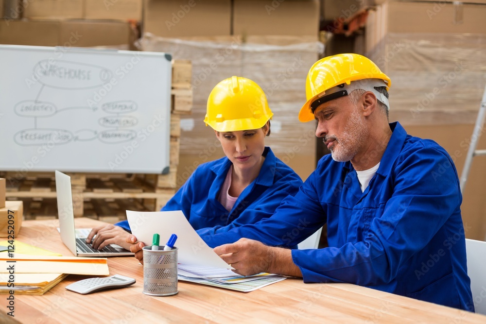 Warehouse workers discussing with each other Warehouse workers discussing with each other