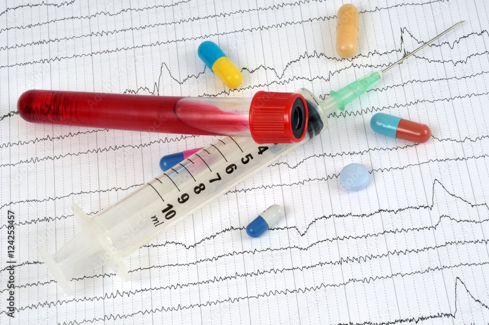 Médicaments, seringue et tube de sang sur une feuille de cardiogramme Stock  Photo | Adobe Stock