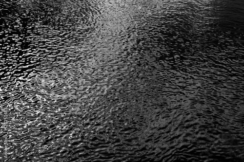 Water in river with small waves in black and white