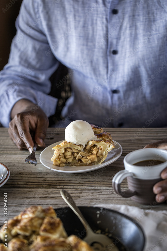 Man eating slice of caramel pie topped with vanilla ice cream and walnuts Man eating slice of caramel pie topped with vanilla ice cream and walnuts