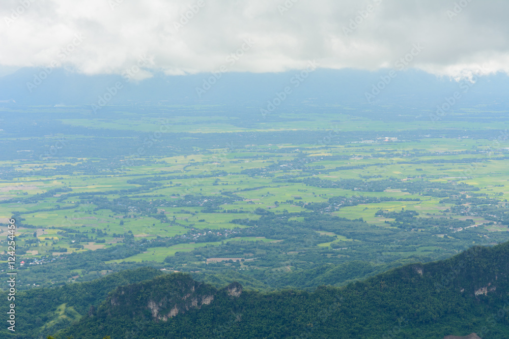 View of the green land from mountain in cloudy day