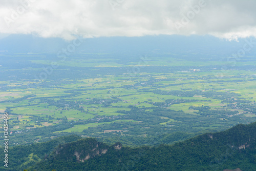 View of the green land from mountain in cloudy day