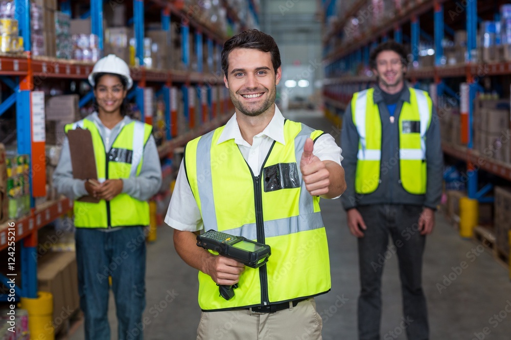 Warehouse worker showing thumbs up sign Warehouse worker showing thumbs up sign