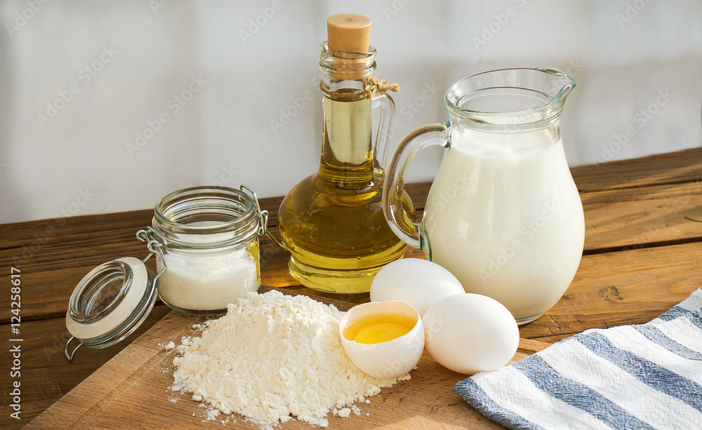 Pancakes ingredients. Milk egg flour oil sugar. Wooden background Pancakes ingredients. Milk egg flour oil sugar. Wooden background