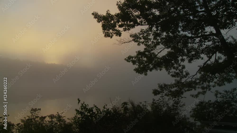 Wide pan of foggy lake during sunset Wide pan of foggy lake during sunset