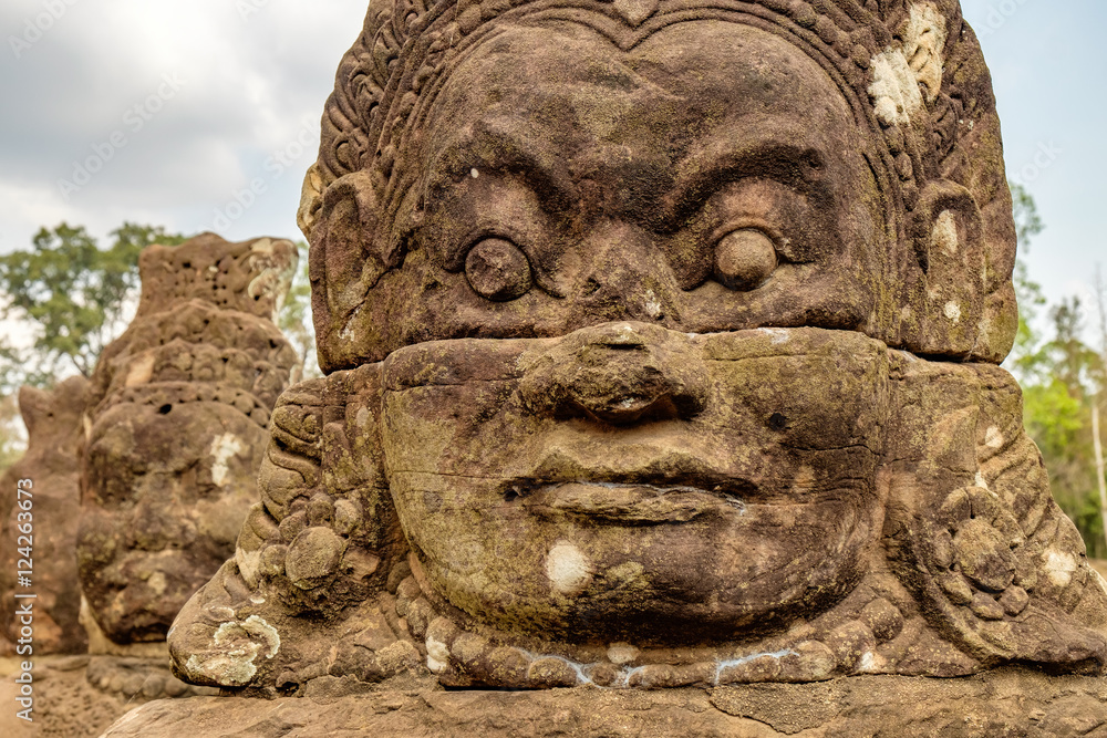 Face of stone giant guarding south gate to Angkor Thom, Cambodia.