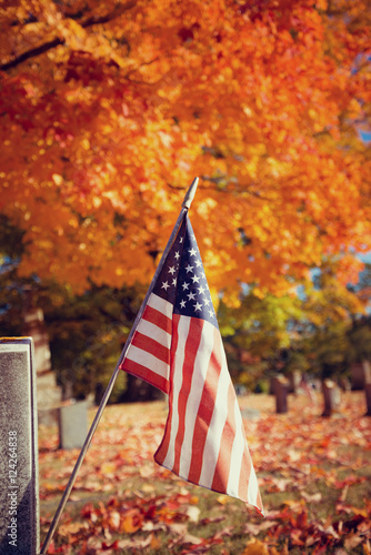 American veteran flag in autumn cemetery. Vintage filter effects.