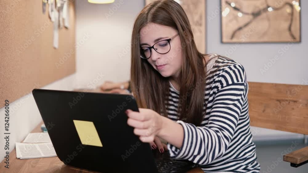 Young attractive girl working with laptop in a modern startup office Young attractive girl working with laptop in a modern startup office
