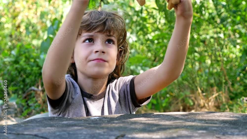 Boy playing with wooden toy airplane on a table outdoors Boy playing with wooden toy airplane on a table outdoors