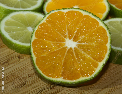 Slices of lime and mandarin on the wooden cutting board