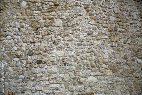 Old looking stone wall structured from variety of rocks