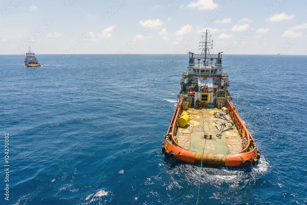 Offshore crew handling anchors on deck tugboat during anchor handling operations at Terengganu oilfield, Malaysia Offshore crew handling anchors on deck tugboat during anchor handling operations at Terengganu oilfield, Malaysia