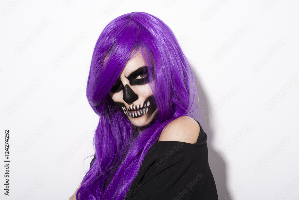 Woman with terrifying skeleton makeup purple hair over white background Woman with terrifying skeleton makeup purple hair over white background