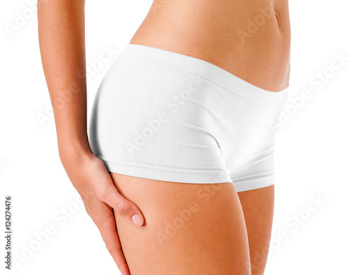 Close-up beautifully fit young woman fitness model midsection in skin tight white boyshorts isolated on white background