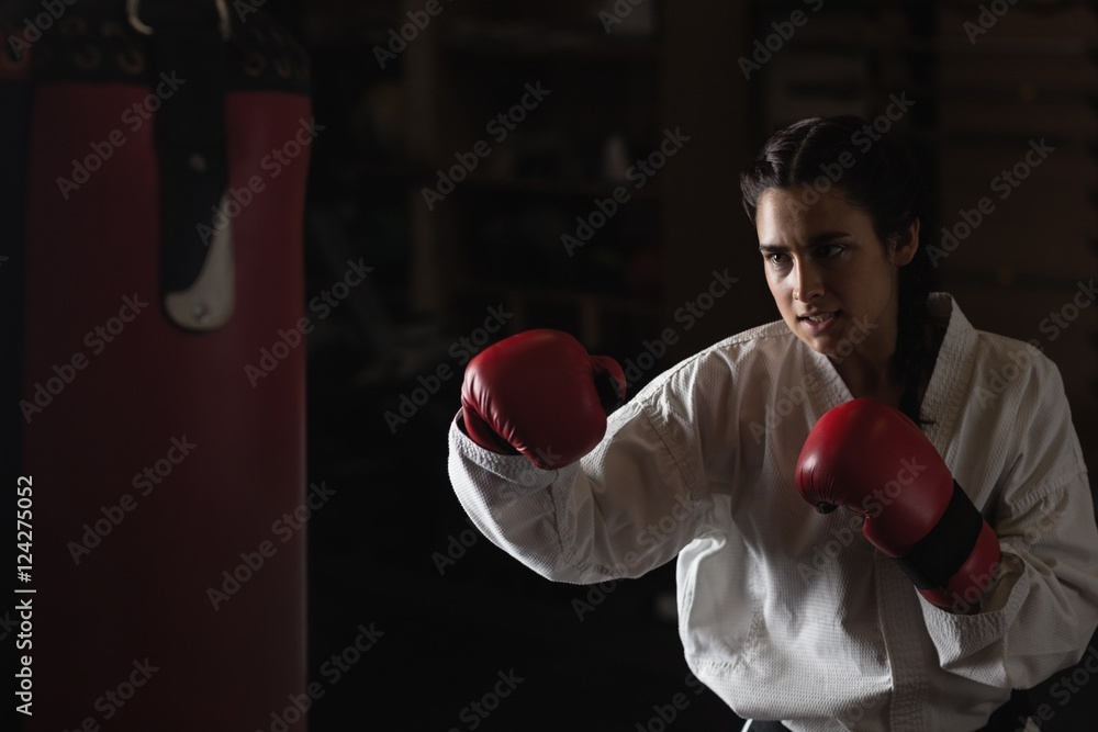 Woman practicing karate with punching bag Woman practicing karate with punching bag