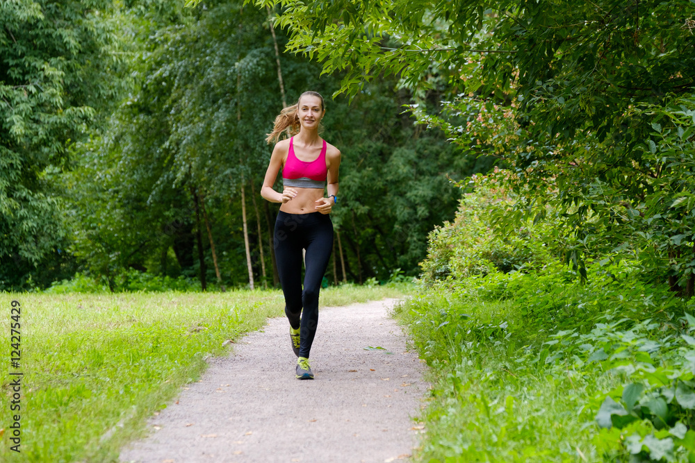 Young slim woman jogging in a park Young slim woman jogging in a park