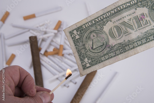 fiamma e dollaro con sfondo di sigarette e sigari photo