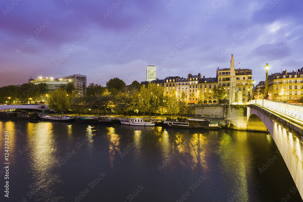 A bridge over a river with illuminated lampposts and buildings A bridge over a river with illuminated lampposts and buildings
