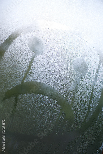Obraz na plátne Sad Face Drawn in Window Condensation