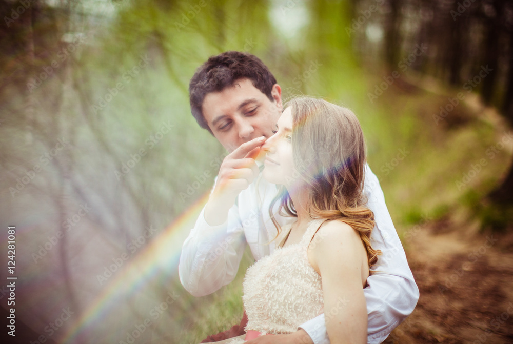 Ray of light lies over a man touching lady's nose Ray of light lies over a man touching lady's nose