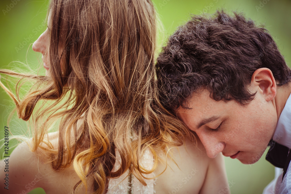 Daydreaming young man lies on woman's shoulder covered with blon Daydreaming young man lies on woman's shoulder covered with blon