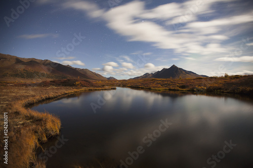 Clouds reflected in a small pond along the dempster highway and landscape;Yukon canada