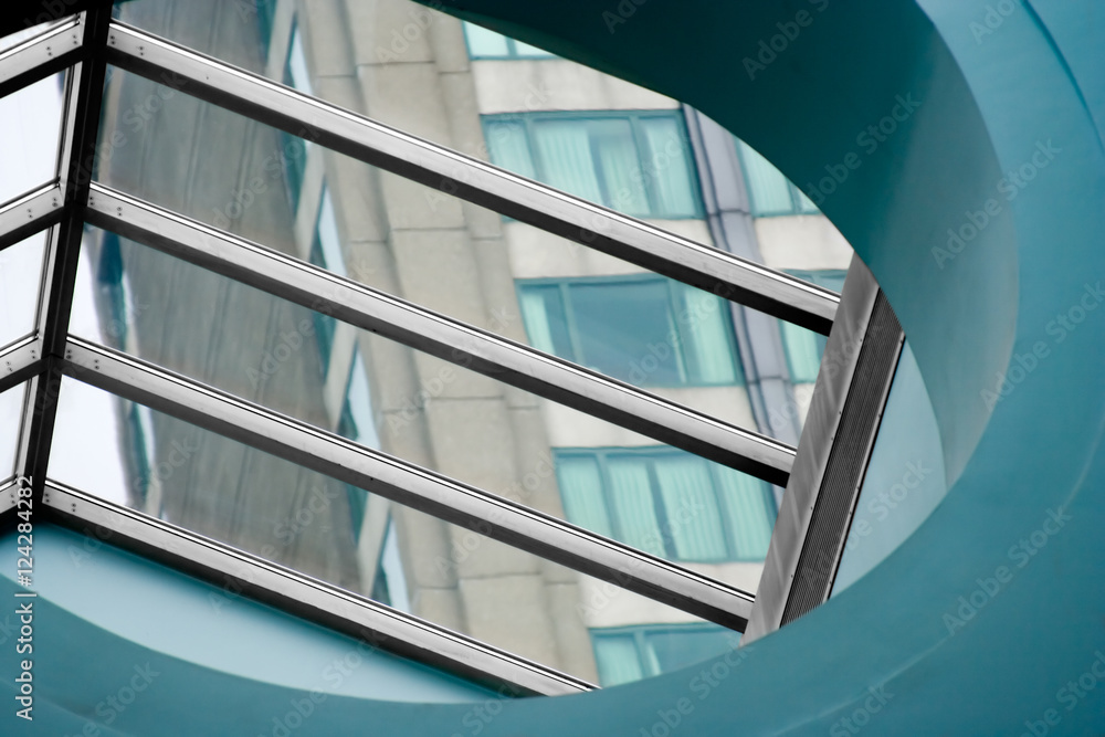 Window with Architectural Elements – A window with metal beams, looking out at a skyscraper building.