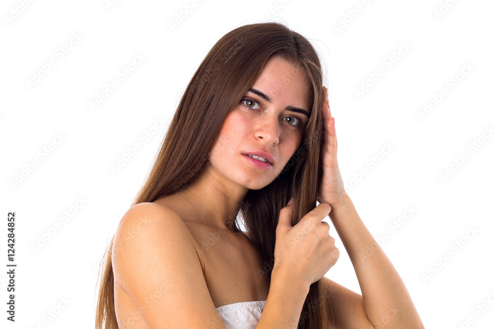 Woman standing sidewise and touching hair