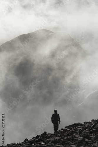 A man walks out of the clouds from the summit of Maol Chean-dearg; Torridon, Scotland photo