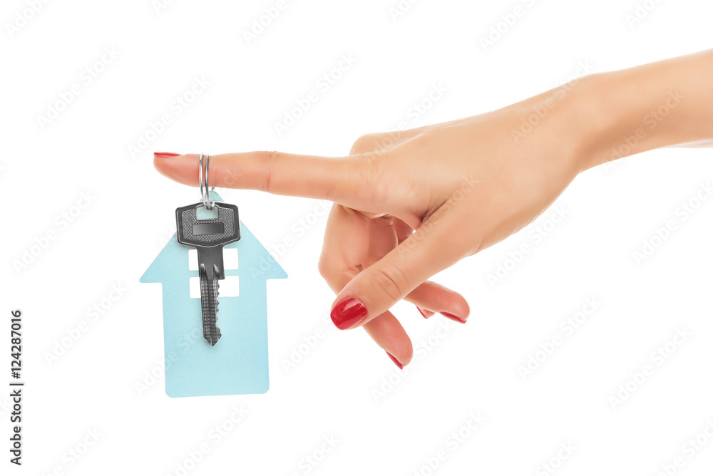 Hand holds key with a keychain the shape of house. Hand holds key with a keychain the shape of house.