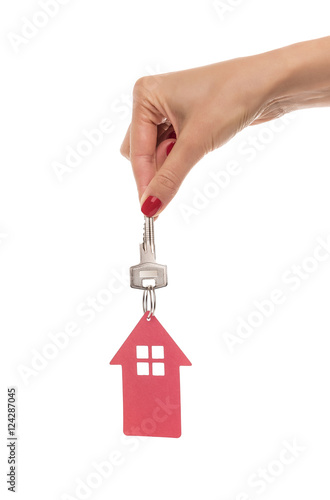 Hand holds key with a keychain the shape of house.