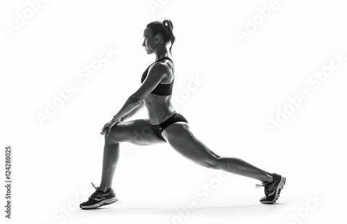 Athletic young woman doing stretching fitness exercise, isolated. Intense stretch pose