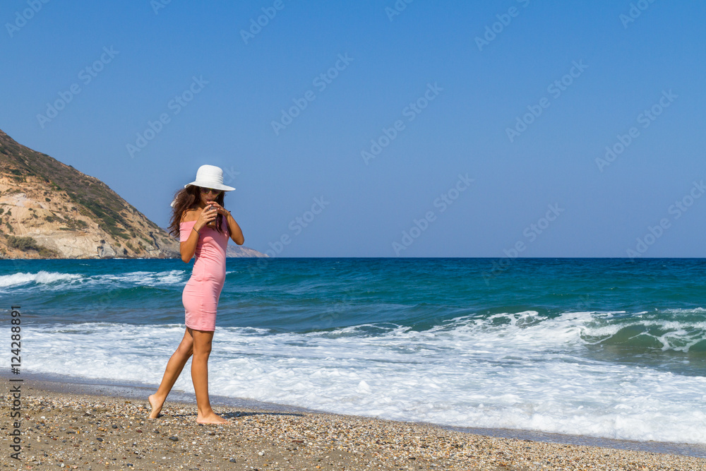 Beautiful carefree woman in short pink dress at the beach. Beautiful carefree woman in short pink dress at the beach.