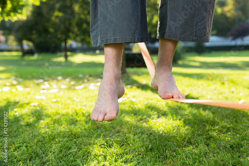 Closeup of mans feet balancing a tightrope or slackline in park © Myvisuals